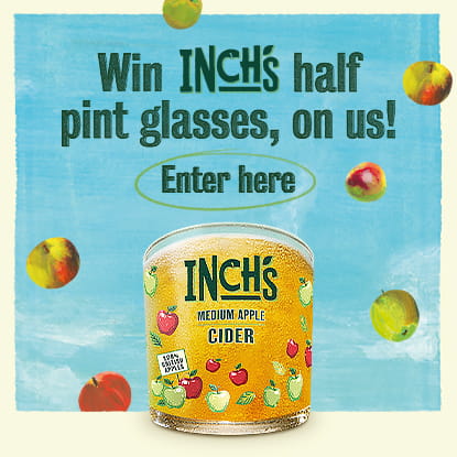 Inch's Cider glass surrounded by apples